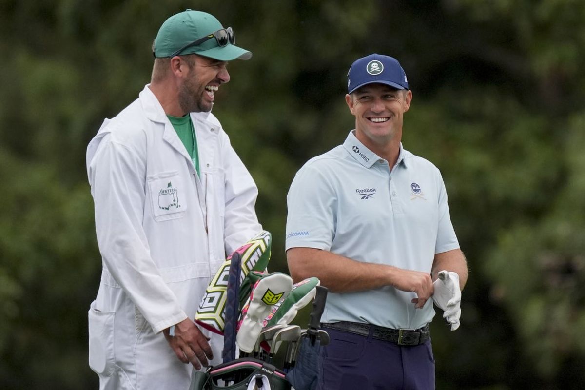 Apr 6, 2026; Augusta, Georgia, USA; Bryson DeChambeau laugs with his caddie, Greg Bodine, on the 15th hole during a practice round for the Masters Tournament at Augusta National Golf Club. Mandatory Credit: Katie Goodale-Imagn Images