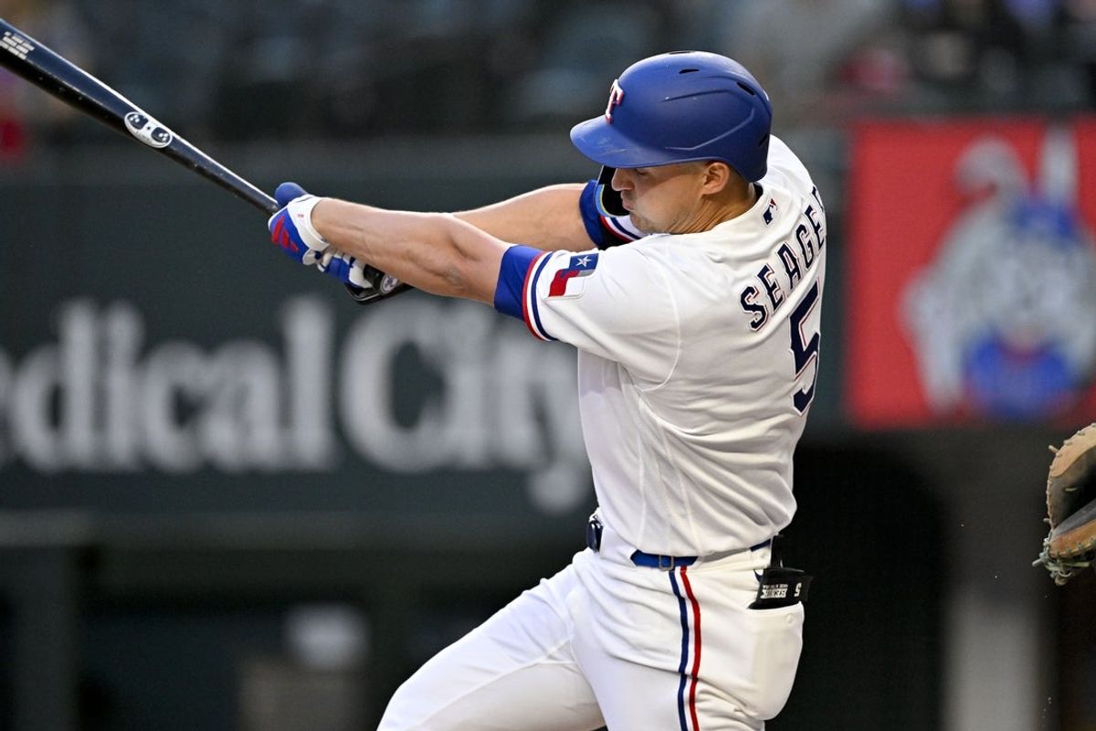 Apr 6, 2026; Arlington, Texas, USA; Texas Rangers shortstop Corey Seager (5) hits a single and drives in a run during the first inning against the Seattle Mariners at Globe Life Field. Mandatory Credit: Jerome Miron-Imagn Images