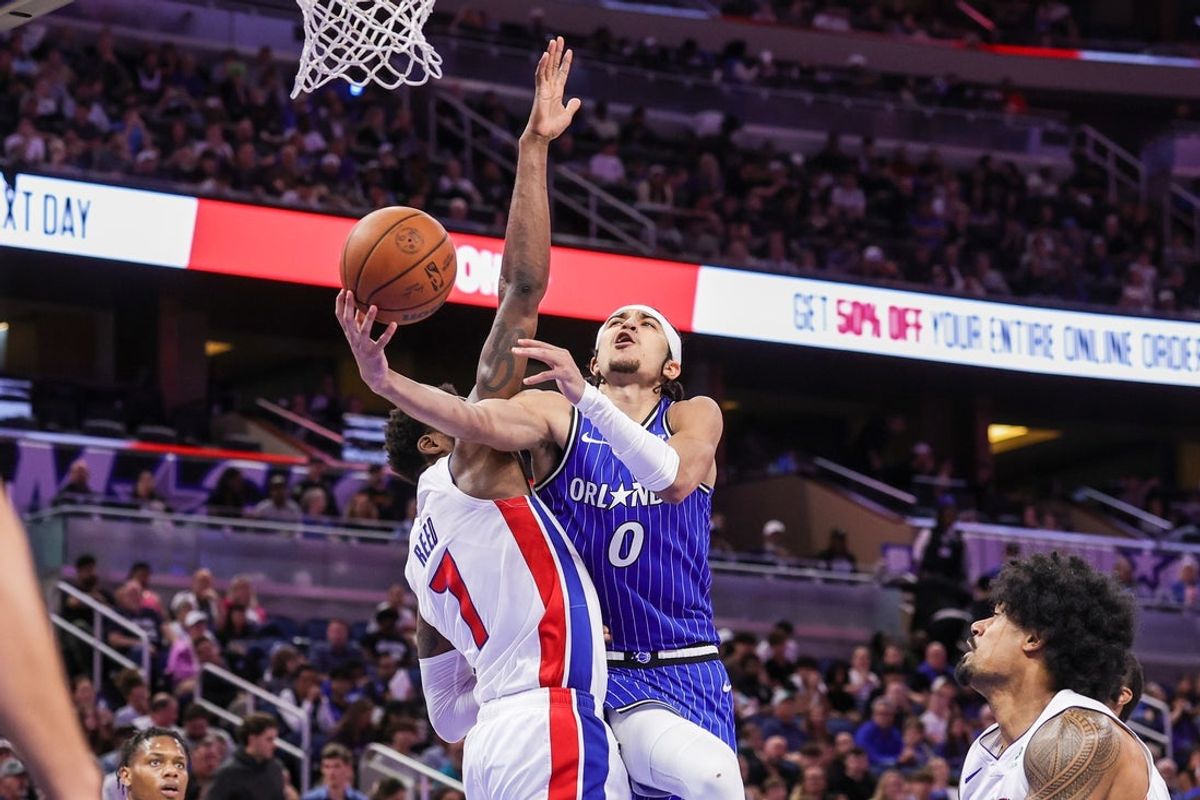 Apr 6, 2026; Orlando, Florida, USA; Orlando Magic guard Anthony Black (0) is fouled by Detroit Pistons forward Paul Reed (7) during the second half at Kia Center. Mandatory Credit: Mike Watters-Imagn Images