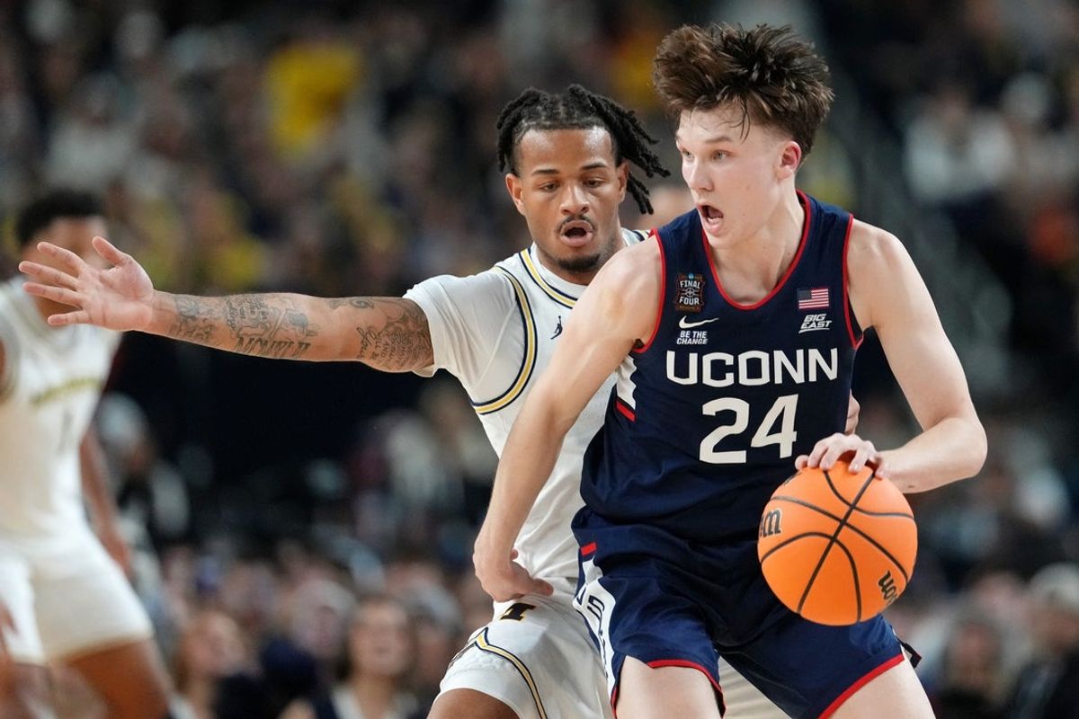 Apr 6, 2026; Indianapolis, IN, USA; UConn Huskies guard Braylon Mullins (24) controls the ball against Michigan Wolverines guard Roddy Gayle Jr. (11) during the second half in the national championship of the Final Four of the men's 2026 NCAA Tournament between the  and the Michigan Wolverines at Lucas Oil Stadium. Mandatory Credit: Bob Donnan-Imagn Images