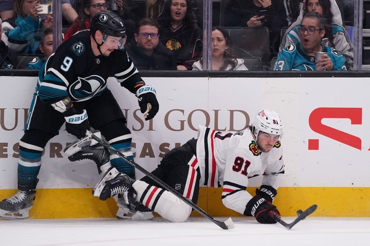 Apr 6, 2026; San Jose, California, USA;  Chicago Blackhawks center Frank Nazar (91) and San Jose Sharks defenseman Dmitry Orlov (9) battle for the puck in the first period at SAP Center at San Jose. Mandatory Credit: David Gonzales-Imagn Images