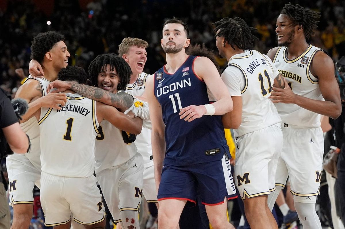 Michigan basketball celebrates winning the NCAA national championship, 69-63, as Connecticut forward Alex Karaban (11) walks off the court at Lucas Oil Stadium in Indianapolis on Monday, April 6, 2026.