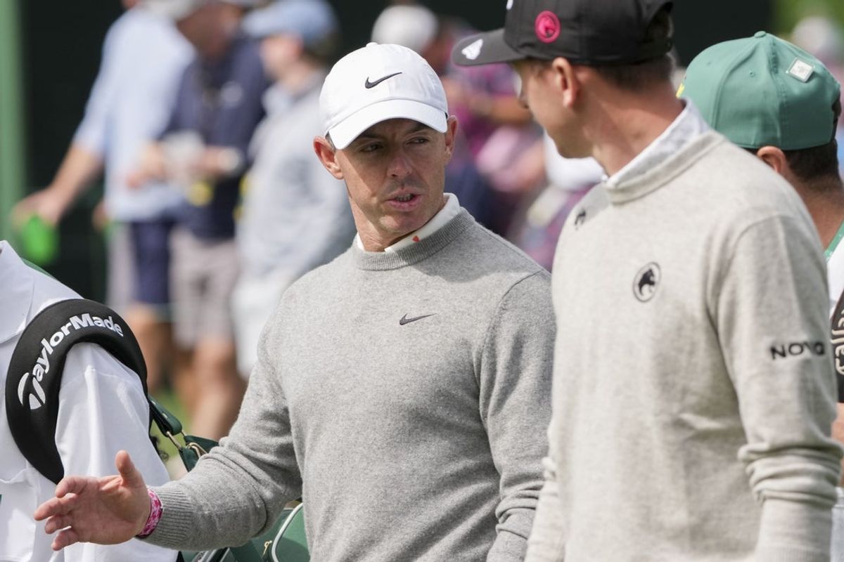 Apr 7, 2026; Augusta, Georgia, USA; Rory McIlroy and Tom McKibbin talk while walking the no. 17 fairway during a practice round for the Masters Tournament at Augusta National Golf Club. Mandatory Credit: Michael Madrid-Imagn Images