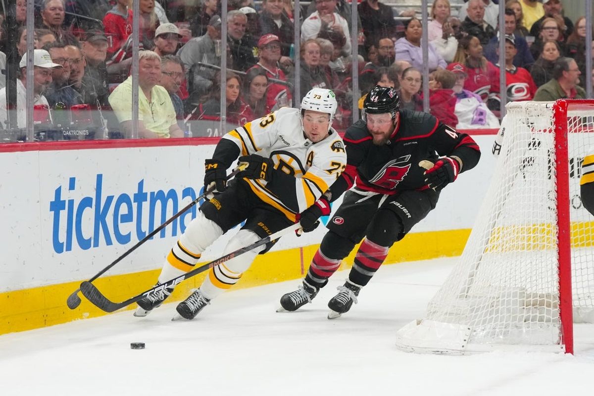 Apr 7, 2026; Raleigh, North Carolina, USA;  Boston Bruins defenseman Charlie McAvoy (73) skates with the puck against Carolina Hurricanes left wing Nicolas Deslauriers (44) during the first period at Lenovo Center. Mandatory Credit: James Guillory-Imagn Images