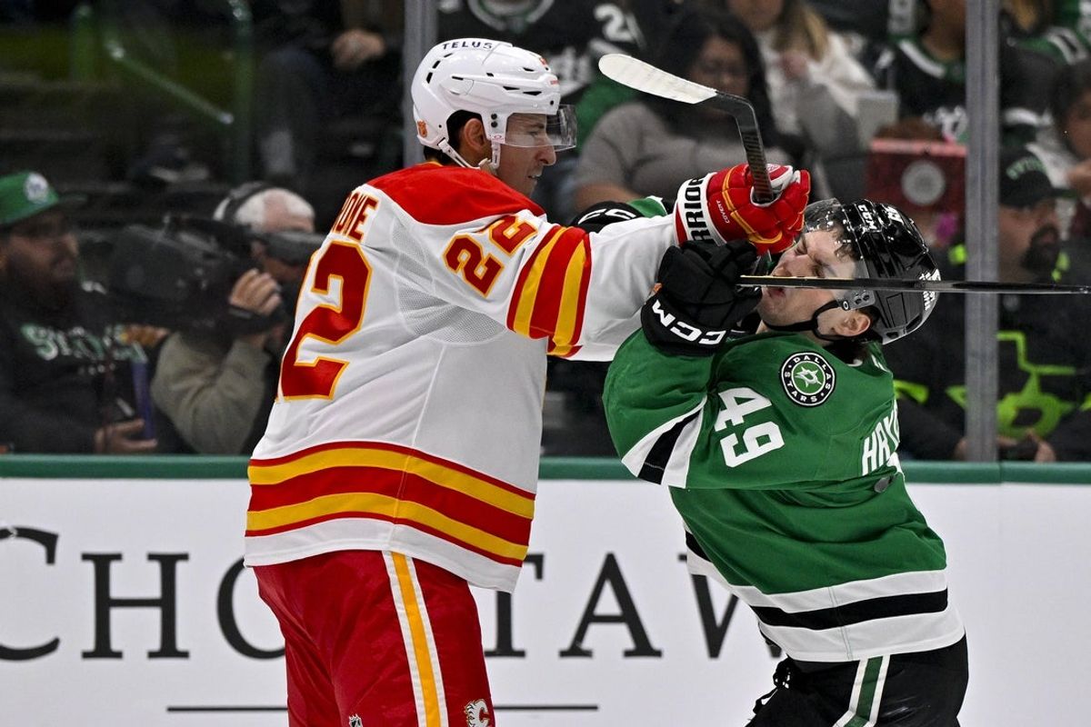 Apr 7, 2026; Dallas, Texas, USA; Calgary Flames center Ryan Strome (22) checks Dallas Stars center Justin Hryckowian (49) during the second period at the American Airlines Center. Mandatory Credit: Jerome Miron-Imagn Images