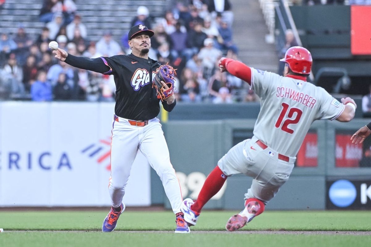 Apr 7, 2026; San Francisco, California, USA; San Francisco Giants infielder Luis Arraez (1) attempts to turn a double play against Philadelphia Phillies left fielder Kyle Schwarber (12) in the first inning at Oracle Park. Mandatory Credit: Ed Szczepanski-Imagn Images