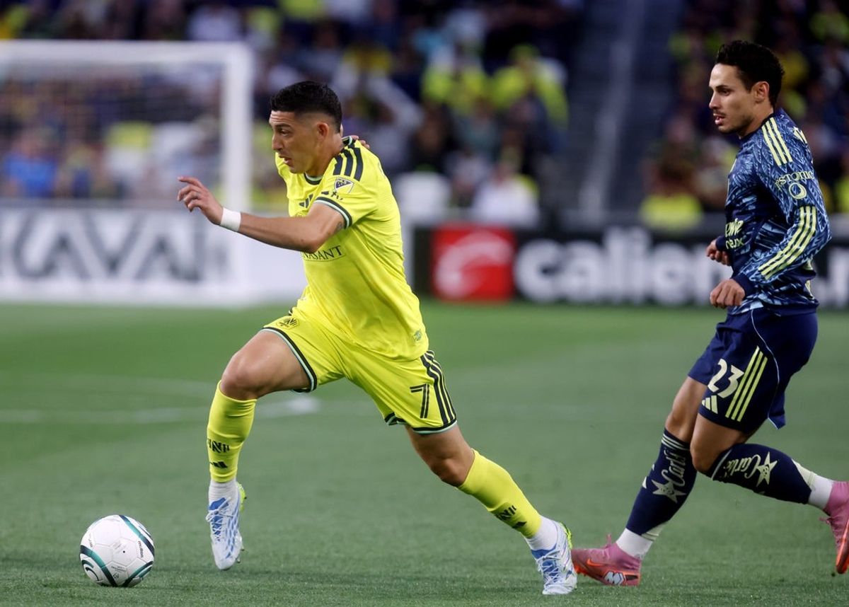 Apr 7, 2026; Nashville, TN, USA; Nashville SC midfielder Cristian Espinoza (7) moves the ball past Club America midfielder Raphael Veiga (23) during the first half of their Concacaf Champions Cup quarterfinal match at Geodis Park. Mandatory Credit: Alan Poizner-Imagn Images