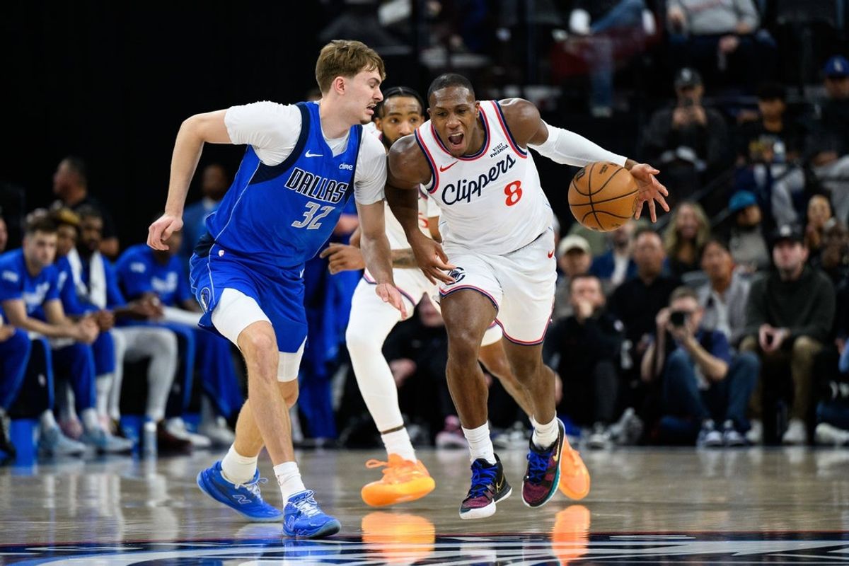 Apr 7, 2026; Inglewood, California, USA; Los Angeles Clippers guard Kris Dunn (8) drives the ball while under pressure from Dallas Mavericks forward Cooper Flagg (32) during the first half at Intuit Dome. Mandatory Credit: William Liang-Imagn Images
