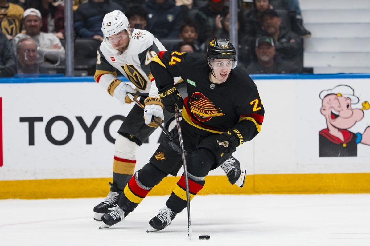 Apr 7, 2026; Vancouver, British Columbia, CAN; Vegas Golden Knights forward Ivan Barbashev (49) stick checks Vancouver Canucks defenseman Zeev Buium (24) in the third period at Rogers Arena. Mandatory Credit: Bob Frid-Imagn Images