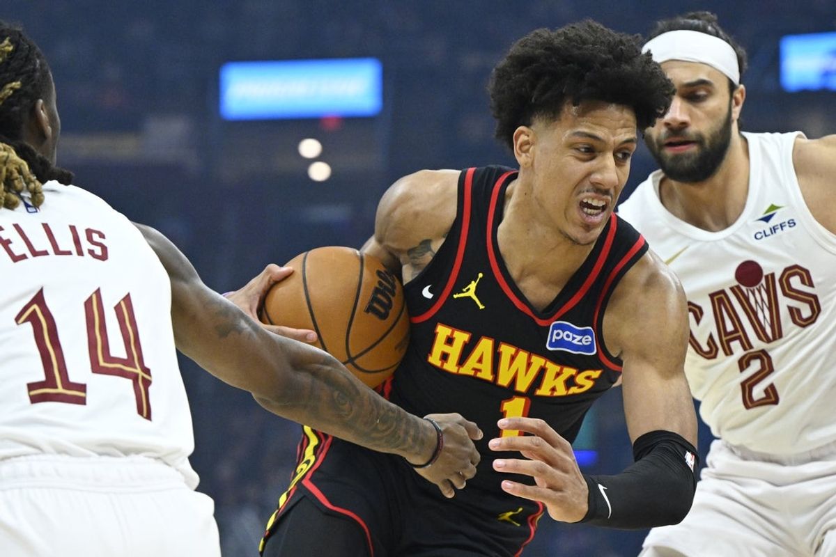 Apr 8, 2026; Cleveland, Ohio, USA; Atlanta Hawks forward Jalen Johnson (1) dribbles between Cleveland Cavaliers guard Keon Ellis (14) and guard Max Strus (2) in the first quarter at Rocket Arena. Mandatory Credit: David Richard-Imagn Images
