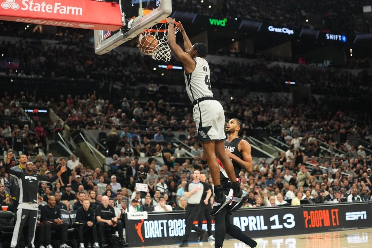 Apr 8, 2026; San Antonio, Texas, USA; San Antonio Spurs guard De’Aaron Fox (4) dunks over Portland Trail Blazers forward Toumani Camara (33) during the first half at Frost Bank Center. Mandatory Credit: Scott Wachter-Imagn Images