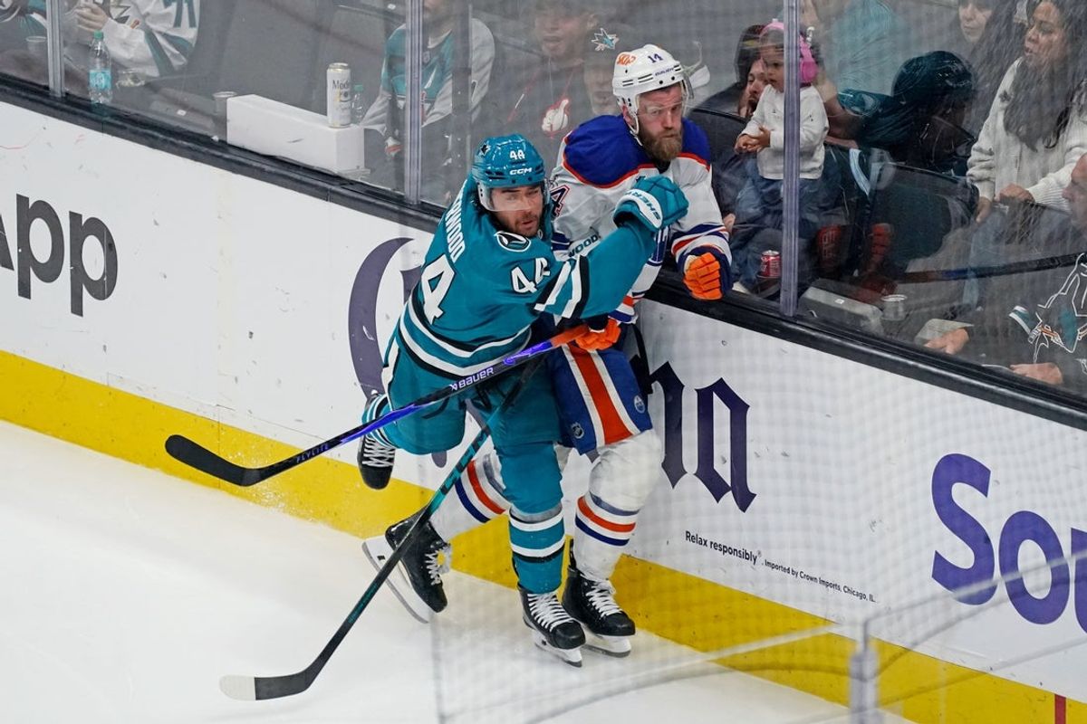 Apr 8, 2026; San Jose, California, USA;  San Jose Sharks left wing Kiefer Sherwood (44) checks Edmonton Oilers defenseman Mattias Ekholm (14) into the boards in the third period at SAP Center at San Jose. Mandatory Credit: David Gonzales-Imagn Images