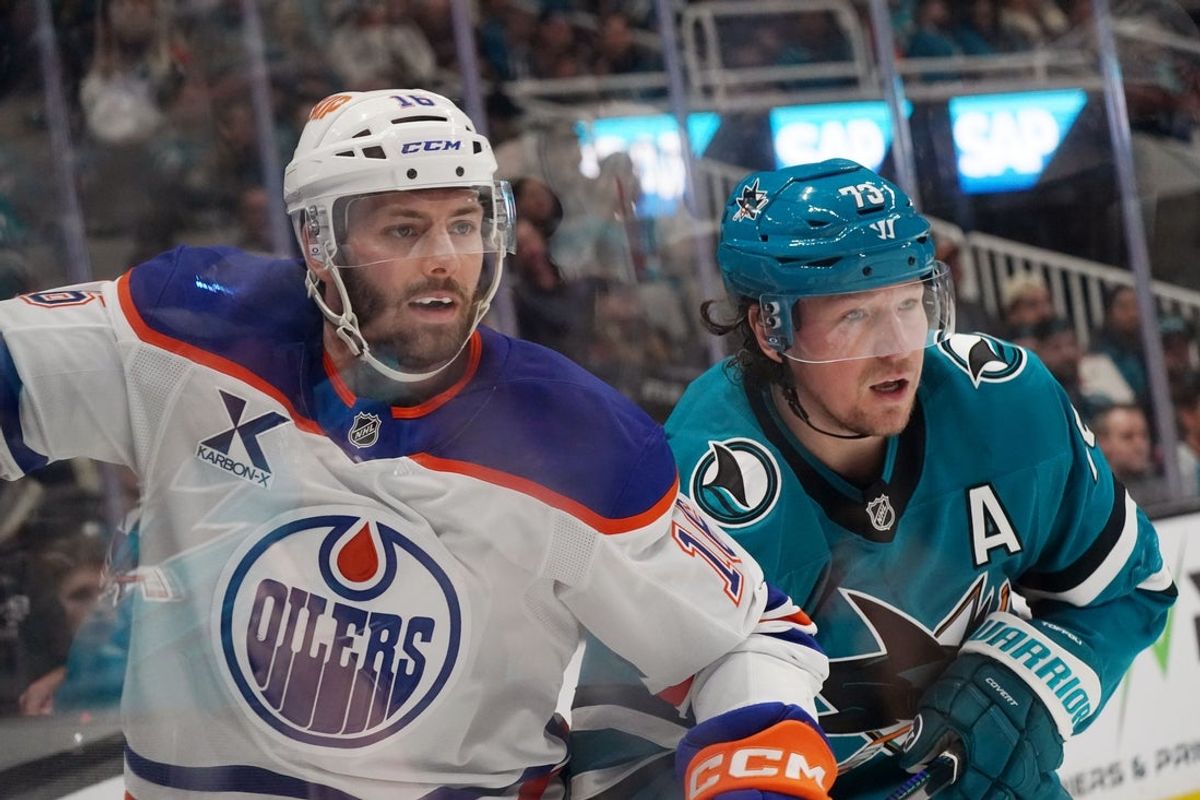 8 de abril de 2026; San José, Califórnia, EUA; O pivô do Edmonton Oilers, Jason Dickinson (16), e o pivô do San Jose Sharks, Tyler Toffoli (73), assistem ao disco no segundo período no SAP Center em San Jose. Crédito obrigatório: David Gonzales-Imagn Images