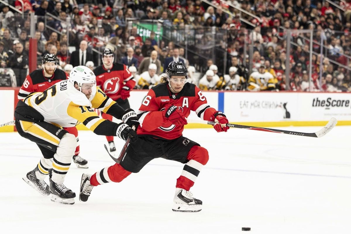 Apr 9, 2026; Newark, New Jersey, USA; New Jersey Devils center Jack Hughes (86) and Pittsburgh Penguins center Tommy Novak (18) fight for the puck during the second period at Prudential Center. Mandatory Credit: Luther Schlaifer-Imagn Images