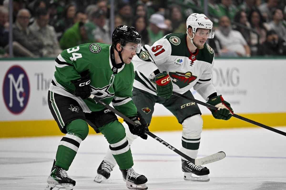 Apr 9, 2026; Dallas, Texas, USA; Dallas Stars center Cameron Hughes (34) and Minnesota Wild right wing Vladimir Tarasenko (91) look for the puck during the first period at the American Airlines Center. Mandatory Credit: Jerome Miron-Imagn Images