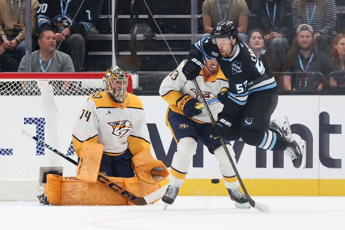 Apr 9, 2026; Salt Lake City, Utah, USA; Utah Mammoth left wing Michael Carcone (53) leaps to avoid a shot against Nashville Predators goaltender Juuse Saros (74) and defenseman Adam Wilsby (83) during the first period at Delta Center. Mandatory Credit: Rob Gray-Imagn Images