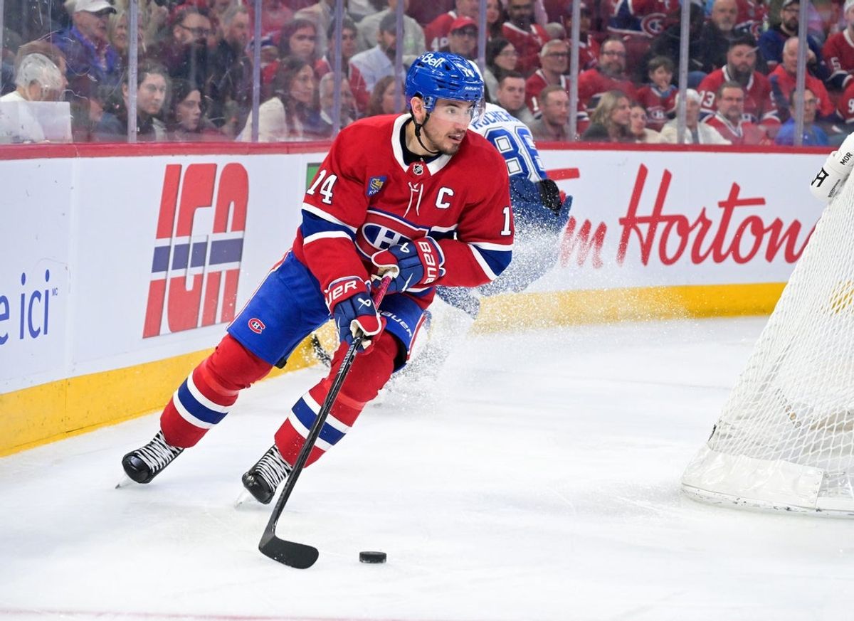 Apr 9, 2026; Montreal, Quebec, CAN; Montreal Canadiens forward Nick Suzuki (14) plays the puck against the Tampa Bay Lightning during the third period at the Bell Centre. Mandatory Credit: Eric Bolte-Imagn Images