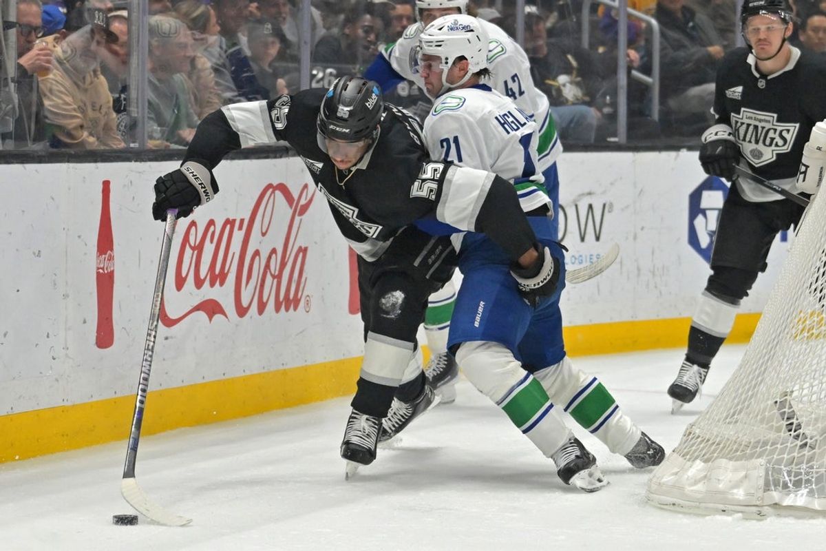 Apr 9, 2026; Los Angeles, California, USA;  Los Angeles Kings right wing Quinton Byfield (55) and Vancouver Canucks left wing Nils Hoglander (21) battle along the boards during the first period at Crypto.com Arena. Mandatory Credit: Jayne Kamin-Oncea-Imagn Images