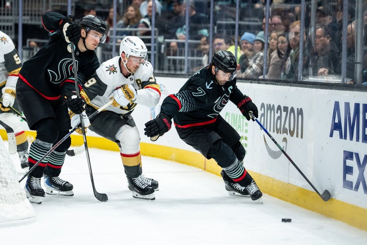 Apr 9, 2026; Seattle, Washington, USA;  Seattle Kraken forward Jordan Eberle (7) and forward Bobby McMann (74), left, battle Vegas Golden Knights forward Jack Eichel (9) for puck during the second period at Climate Pledge Arena. Mandatory Credit: Stephen Brashear-Imagn Images