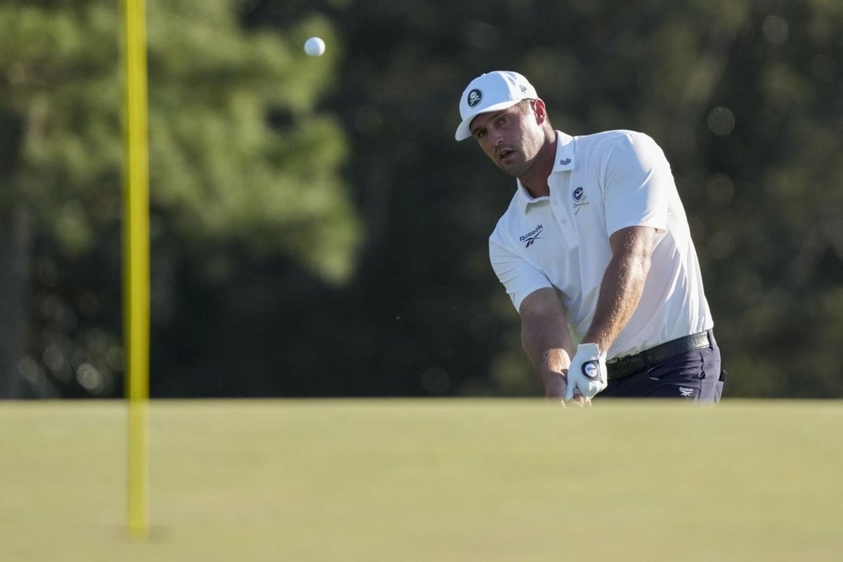 Apr 10, 2026; Augusta, Georgia, USA; Bryson DeChambeau chips onto the 18th green during the second round of the Masters Tournament at Augusta National Golf Club. Mandatory Credit: Grace Smith-Imagn Images