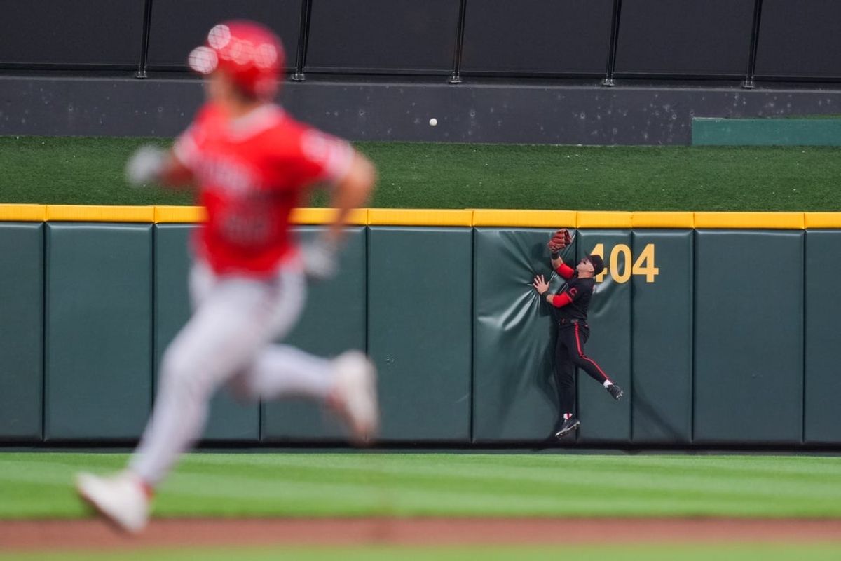 Apr 10, 2026; Cincinnati, Ohio, USA;  Cincinnati Reds center fielder TJ Friedl (29) crashes into the wall as he attempts to catch a two-run home run hit by Los Angeles Angels shortstop Zach Neto (9) in the fourth inning at Great American Ball Park. Mandatory Credit: Aaron Doster-Imagn Images