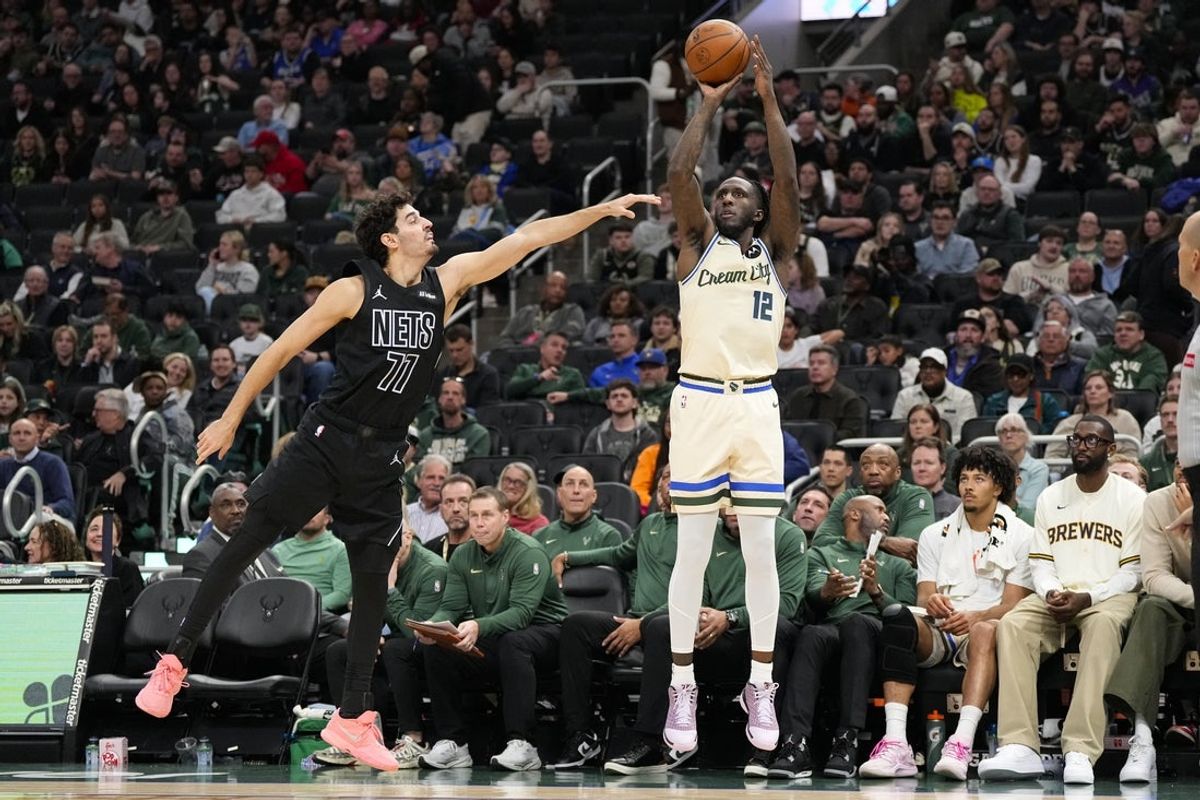 Apr 10, 2026; Milwaukee, Wisconsin, USA;  Milwaukee Bucks forward Taurean Prince (12) shoots against Brooklyn Nets guard Ben Saraf (77) during the second quarter at Fiserv Forum. Mandatory Credit: Jeff Hanisch-Imagn Images