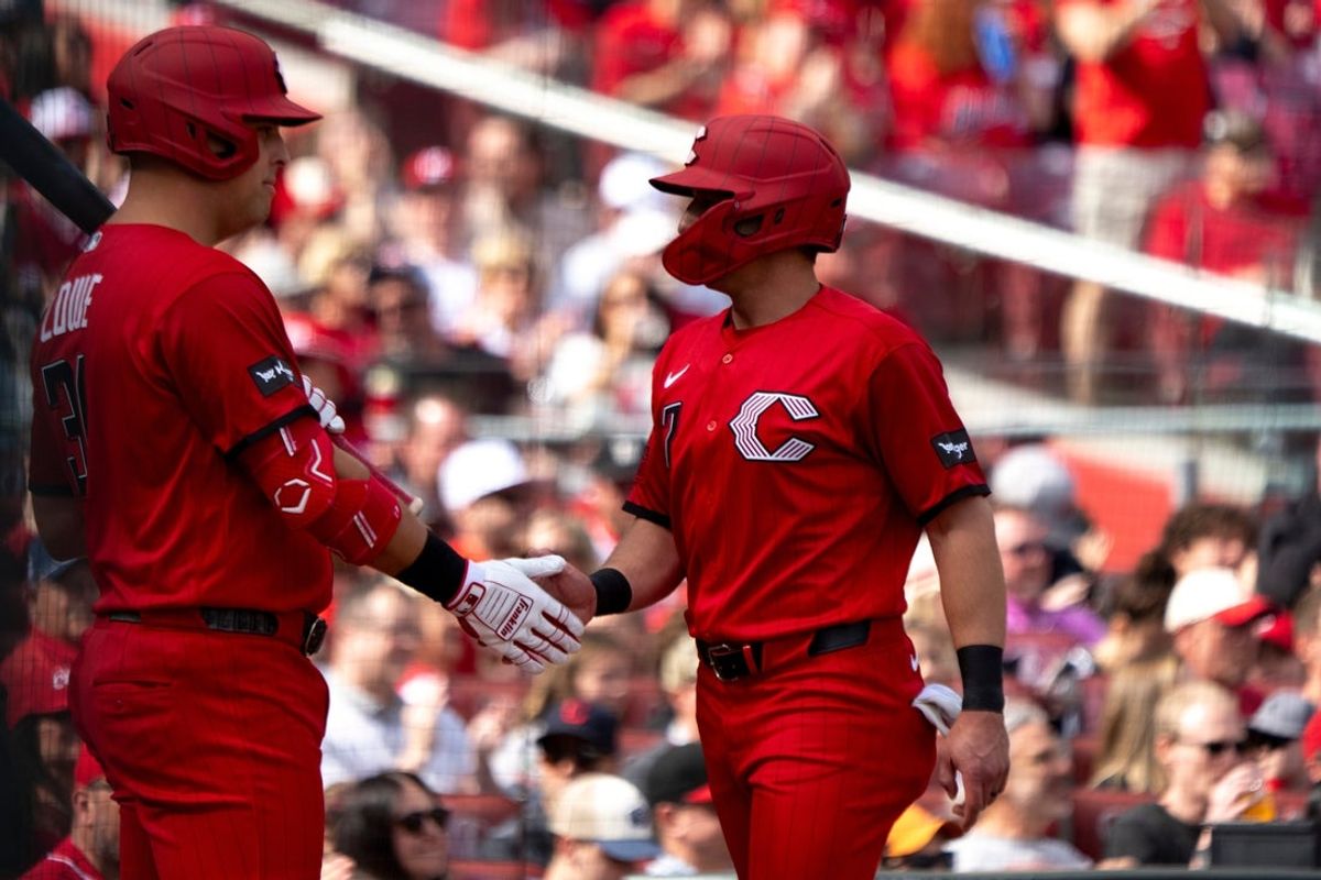 Cincinnati Reds left fielder Spencer Steer (7) high fives Cincinnati Reds first baseman Nathaniel Lowe (31) after scoring off a base hit in the first inning between the Cincinnati Reds and the Los Angeles Angels at Great American Ball in Cincinnati on Saturday, April 11, 2026.