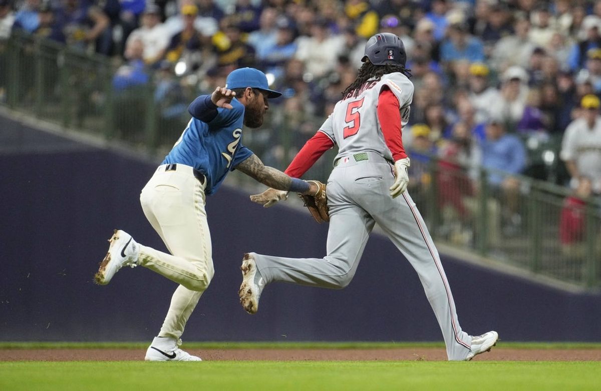 Apr 11, 2026; Milwaukee, Wisconsin, USA; Washington Nationals shortstop CJ Abrams (5) is tagged out by Milwaukee Brewers shortstop Joey Ortiz (3) as he gets caught in a run down in the fourth inning at American Family Field. Mandatory Credit: Michael McLoone-Imagn Images