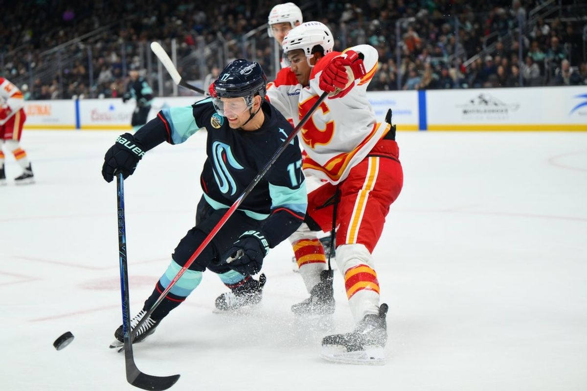 Apr 11, 2026; Seattle, Washington, USA; Seattle Kraken left wing Jaden Schwartz (17) and Calgary Flames defenseman Zayne Parekh (19) fight for the puck during the second period at Climate Pledge Arena. Mandatory Credit: Steven Bisig-Imagn Images