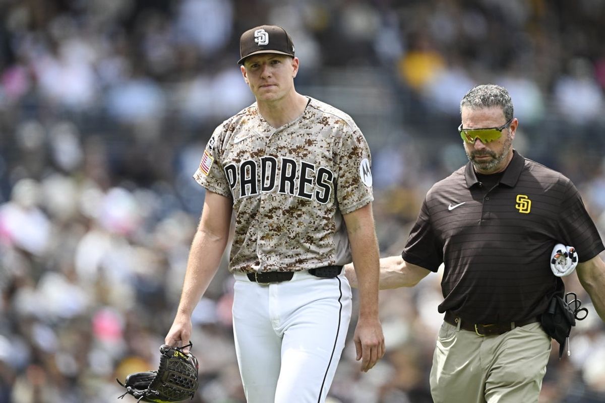 Apr 12, 2026; San Diego, California, USA; San Diego Padres starting pitcher Nick Pivetta (27), left, leaves the field with a trainer during the fourth inning against the Colorado Rockies at Petco Park. Mandatory Credit: Denis Poroy-Imagn Images