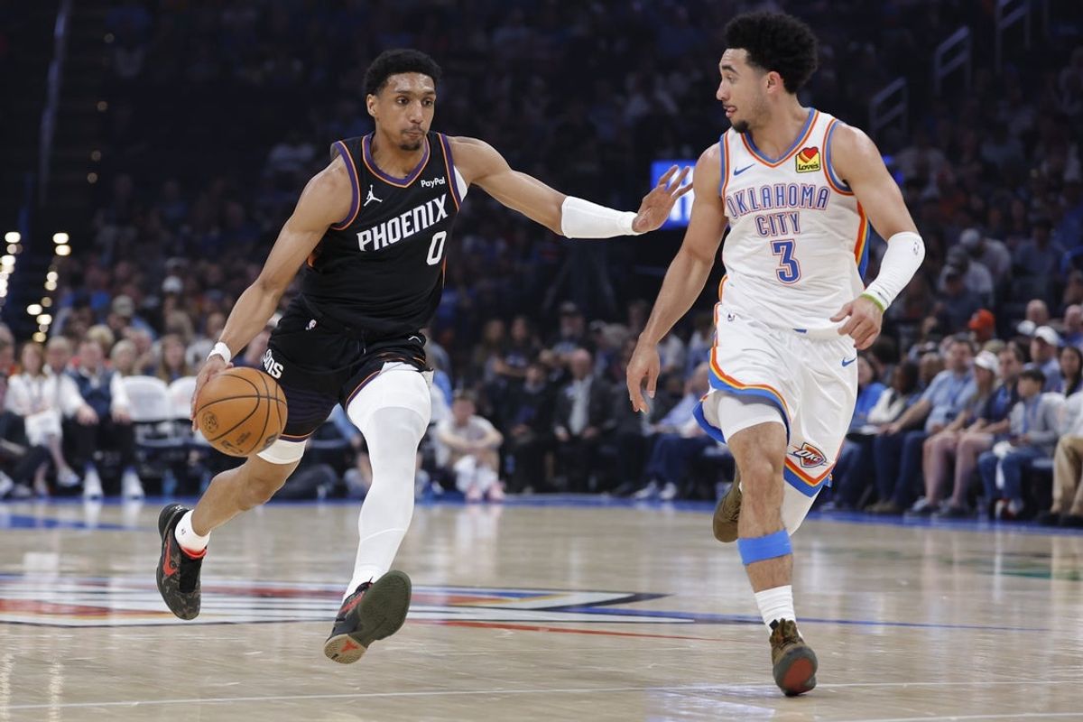 Apr 12, 2026; Oklahoma City, Oklahoma, USA; Phoenix Suns forward Ryan Dunn (0) drives down the court beside Oklahoma City Thunder guard Jared McCain (3) during the first half at Paycom Center. Mandatory Credit: Alonzo Adams-Imagn Images