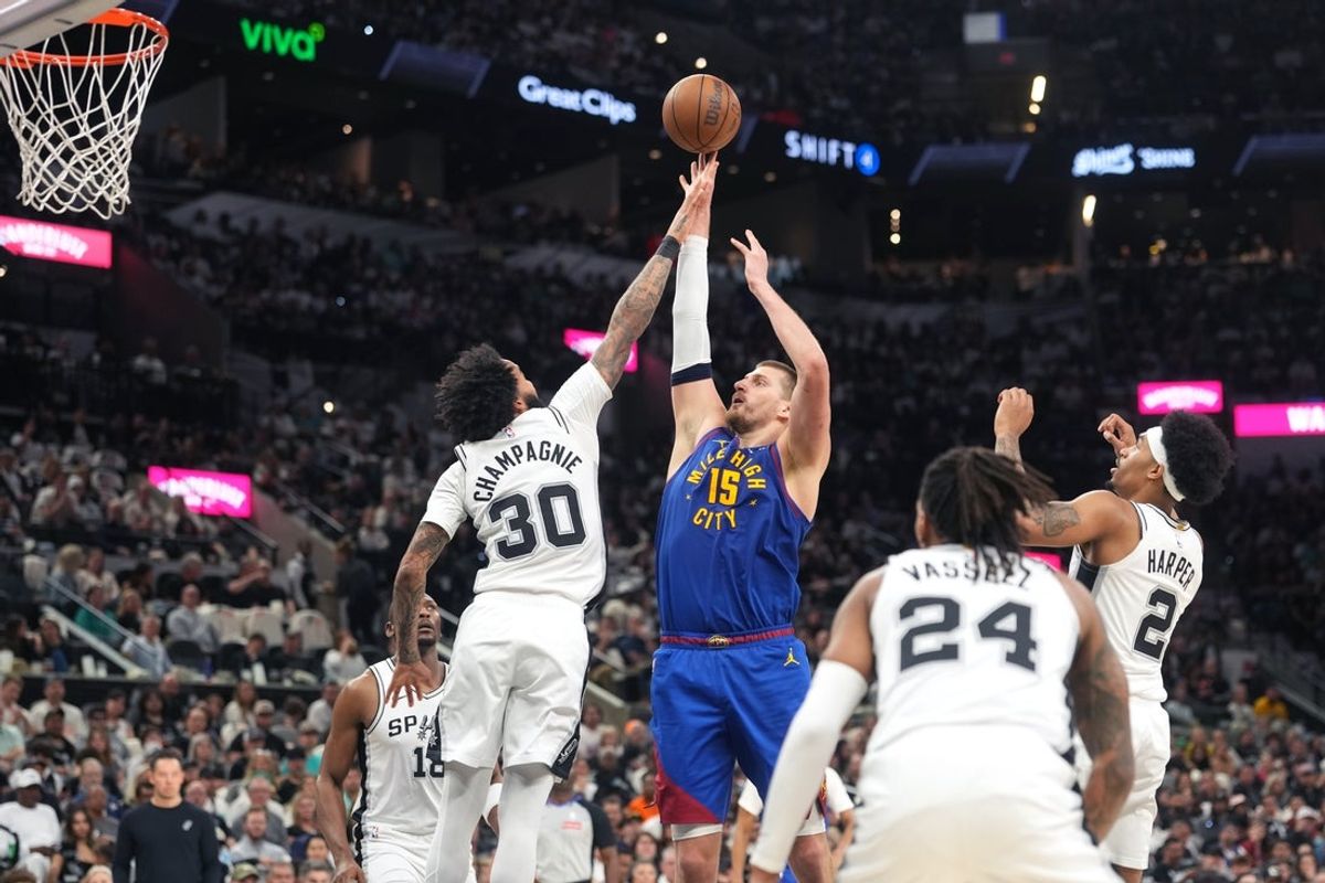 Apr 12, 2026; San Antonio, Texas, USA; Denver Nuggets center Nikola Jokic (15) shoots over San Antonio Spurs forward Julian Champagnie (30) during the first half at Frost Bank Center. Mandatory Credit: Scott Wachter-Imagn Images