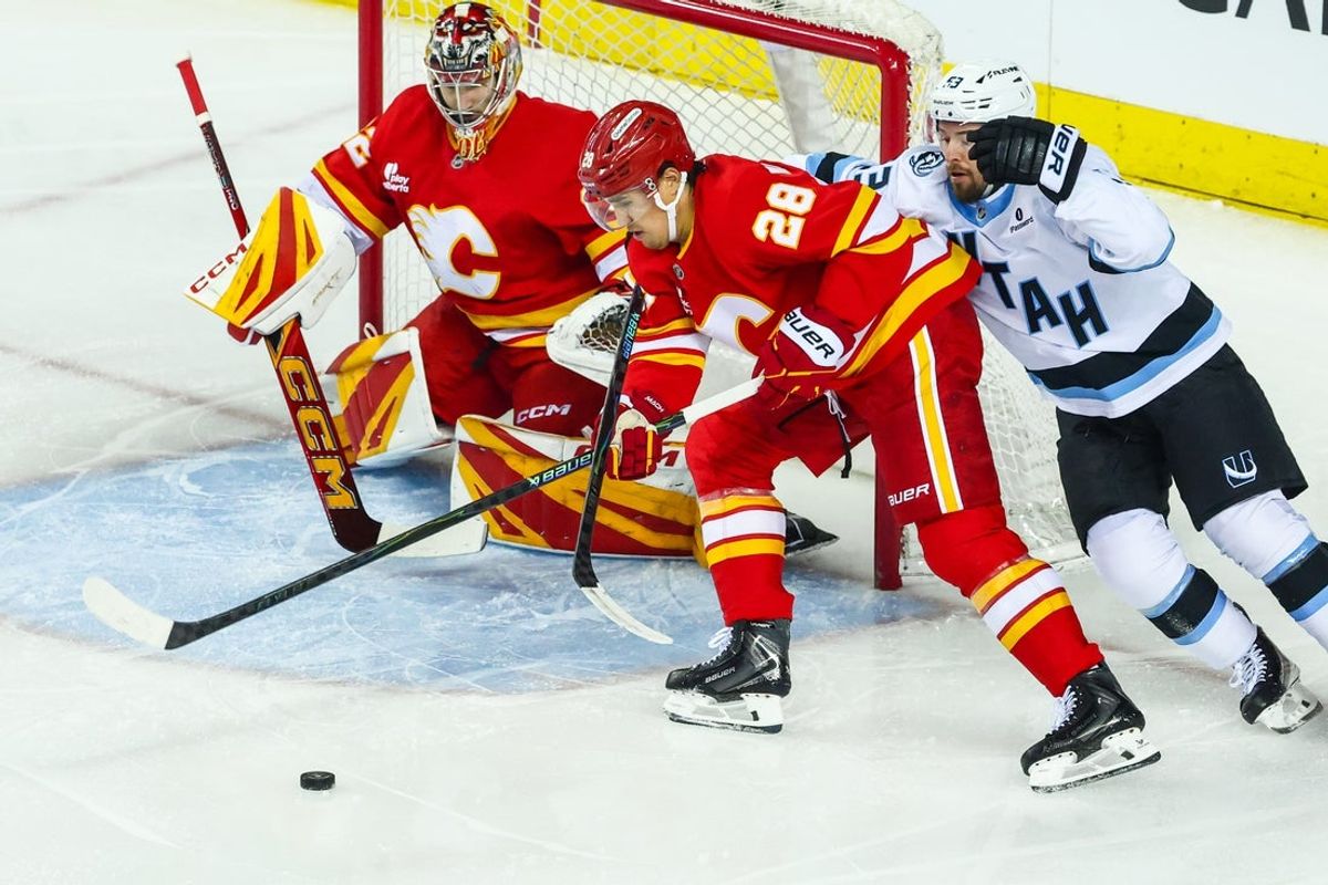 Apr 12, 2026; Calgary, Alberta, CAN; Calgary Flames defenseman Zach Whitecloud (28) and Utah Mammoth left wing Michael Carcone (53) battle for the puck in front of Calgary Flames goaltender Dustin Wolf (32) during the first period at Scotiabank Saddledome. Mandatory Credit: Sergei Belski-USA TODAY Sports