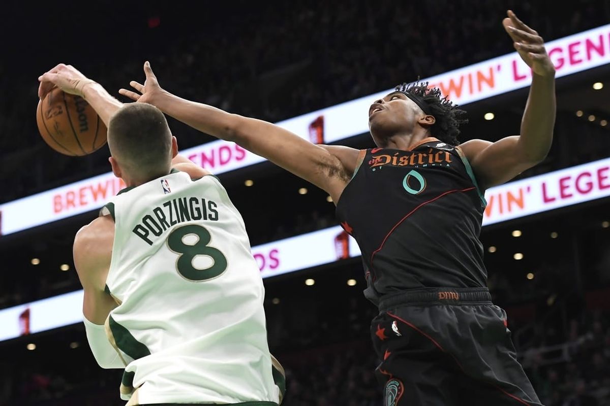 Feb 9, 2024; Boston, Massachusetts, USA; Boston Celtics center Kristaps Porzingis (8) blocks the shot of Washington Wizards guard Bilal Coulibaly (0) during the first half at TD Garden.