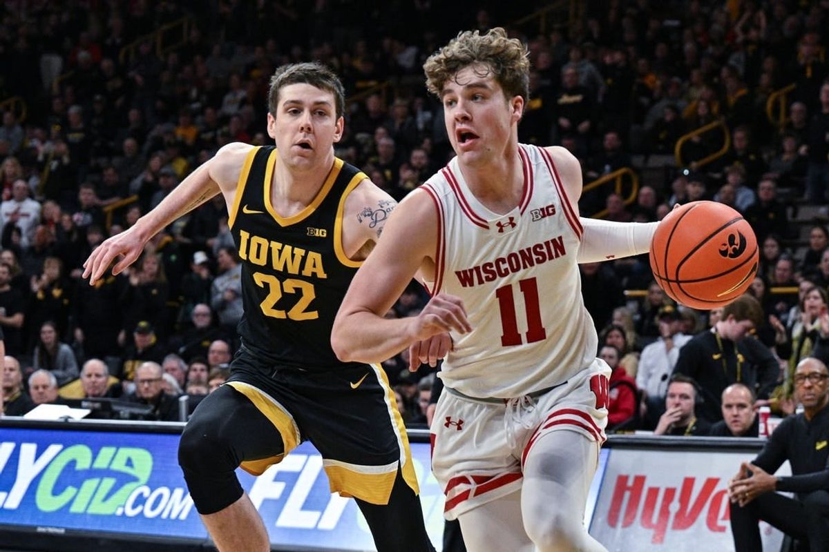 Feb 17, 2024; Iowa City, Iowa, USA; Wisconsin Badgers guard Max Klesmit (11) goes to the basket as Iowa Hawkeyes forward Patrick McCaffery (22) defends during the first half at Carver-Hawkeye Arena.