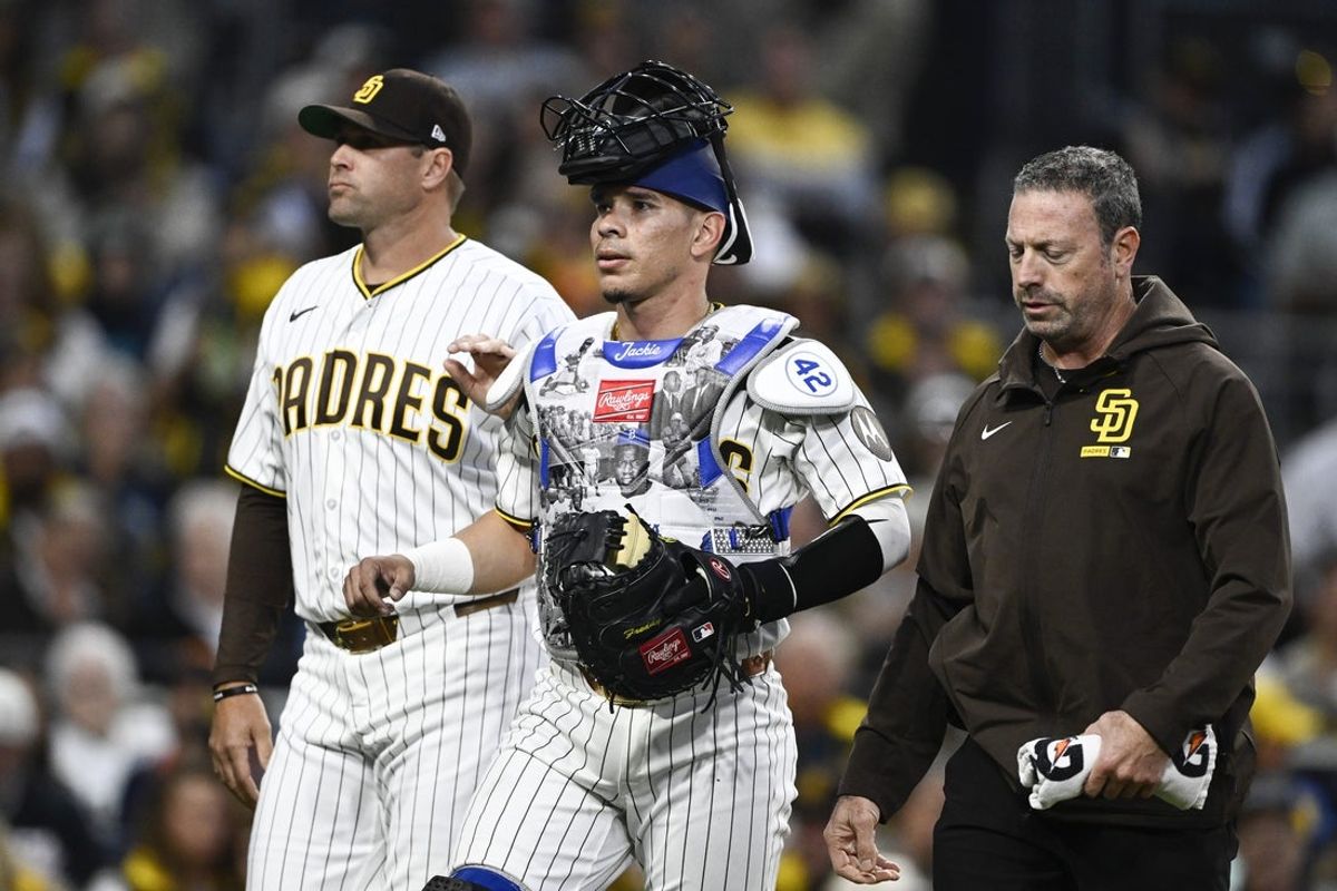 Apr 15, 2026; San Diego, California, USA; San Diego Padres catcher Freddy Fermin, center, leaves the game next to manager Craig Stammen, left, and a trainer during the third inning against the Seattle Mariners at Petco Park. All MLB players are wearing number 42 today to honor Jackie Robinson. Mandatory Credit: Denis Poroy-Imagn Images