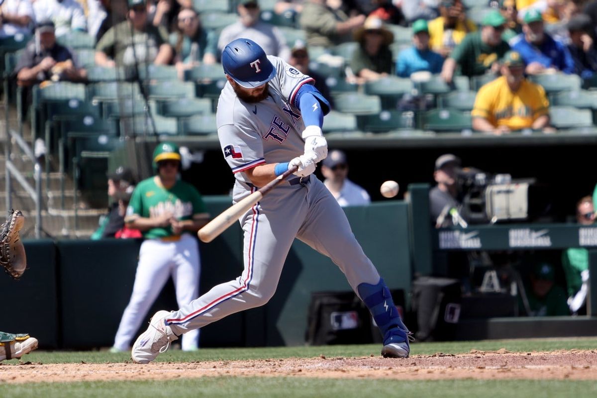 Apr 16, 2026; West Sacramento, California, USA; Texas Rangers first baseman Jake Burger (21) hits a RBI sacrifice fly against the Athletics during the fifth inning at Sutter Health Park. Mandatory Credit: Dennis Lee-Imagn Images
