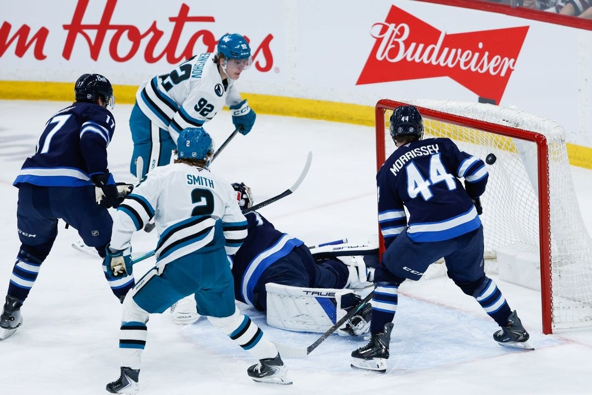 Apr 16, 2026; Winnipeg, Manitoba, CAN;  San Jose Sharks forward Igor Chernyshov (92) scores on Winnipeg Jets goalie Eric Comrie (1) during the first period at Canada Life Centre. Mandatory Credit: Terrence Lee-Imagn Images