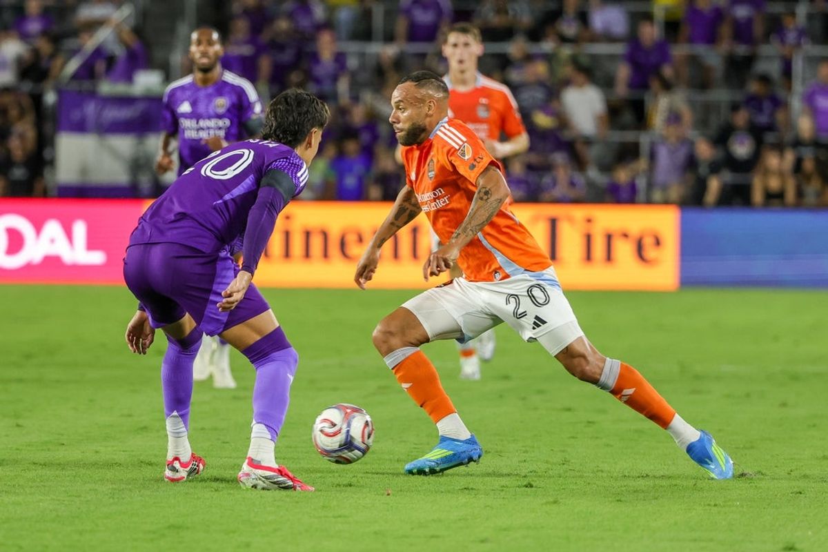Apr 18, 2026; Orlando, Florida, USA; Houston Dynamo FC midfielder Guilherme Santos (20) dribbles the ball against Orlando City SC midfielder Eduard Atuesta (20) during the first half at Inter&Co Stadium. Mandatory Credit: Mike Watters-Imagn Images