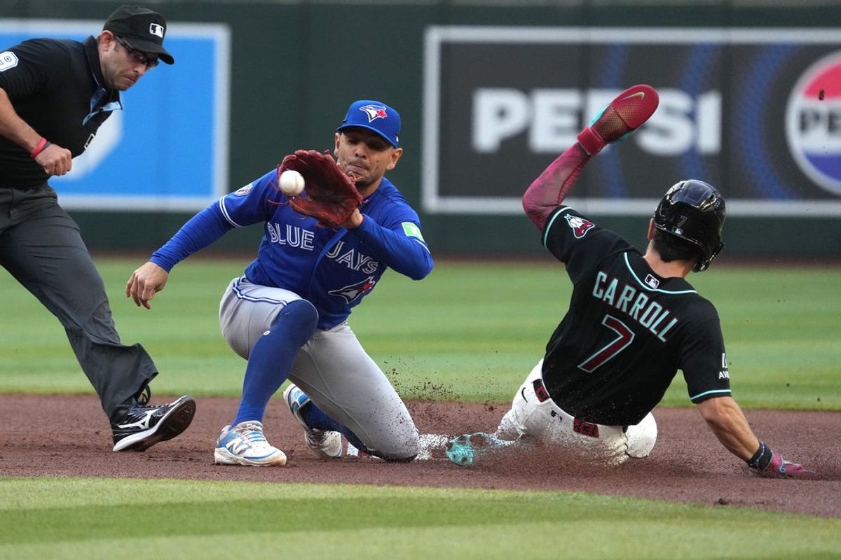 Apr 18, 2026; Phoenix, Arizona, USA; Arizona Diamondbacks right fielder Corbin Carroll (7) steals secondbase under the tag by Toronto Blue Jays second baseman Andrés Giménez (0) in the first inning at Chase Field. Mandatory Credit: Rick Scuteri-Imagn Images