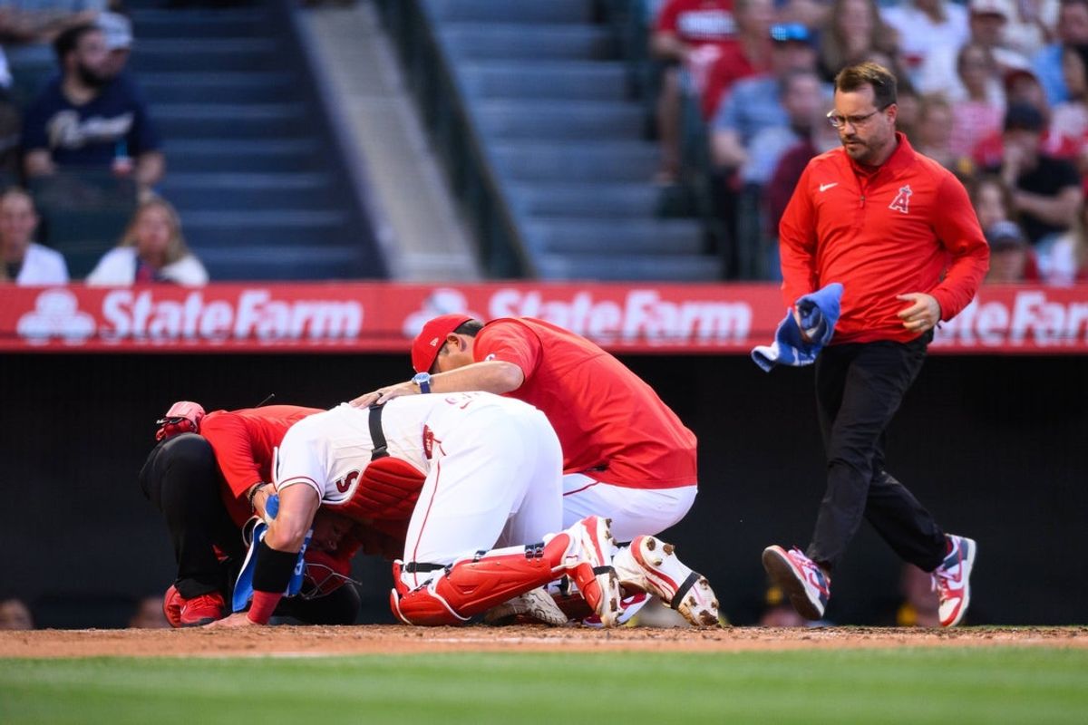 Apr 18, 2026; Anaheim, California, USA; Los Angeles Angels catcher Logan O'Hoppe (14) is checked on my medical staff after being hit by a foul ball during the second inning against the San Diego Padres at Angel Stadium. Mandatory Credit: William Liang-Imagn Images
