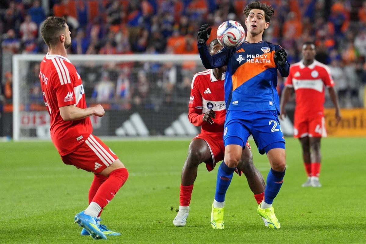 Apr 18, 2026; Cincinnati, Ohio, USA; FC Cincinnati midfielder Pavel Bucha (20) (center) collects a pass as Chicago Fire FC midfielder Dje D’avilla (42) defends during the second half of an MLS match at TQL Stadium. Mandatory Credit: Kareem Elgazzar-Imagn Images