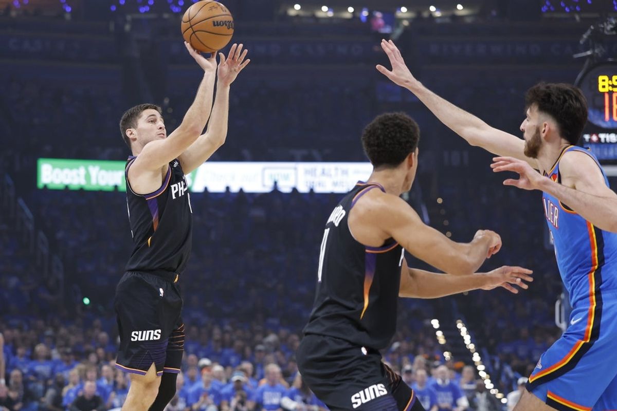 19 de abril de 2026; Cidade de Oklahoma, Oklahoma, EUA; O armador do Phoenix Suns, Collin Gillespie (12), chuta enquanto o pivô do Oklahoma City Thunder, Chet Holmgren (7), defende no primeiro quarto durante o primeiro jogo da primeira rodada dos Playoffs da NBA de 2026 no Paycom Center. Crédito obrigatório: Alonzo Adams-Imagn Images
