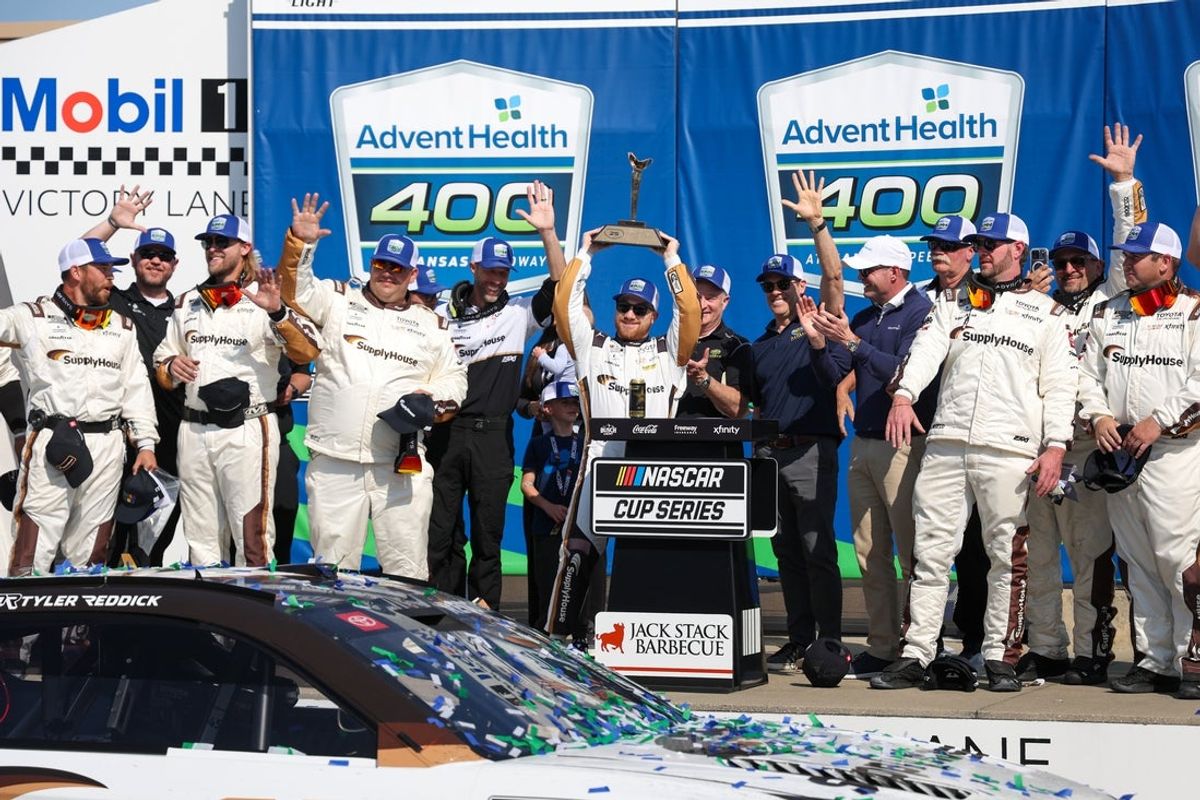Apr 19, 2026; Kansas City, Kansas, USA; NASCAR Cup Series driver Tyler Reddick (45) holds up the winner’s trophy after winning the AdventHealth 400 at Kansas Speedway. Mandatory Credit: Scott Sewell-Imagn Images