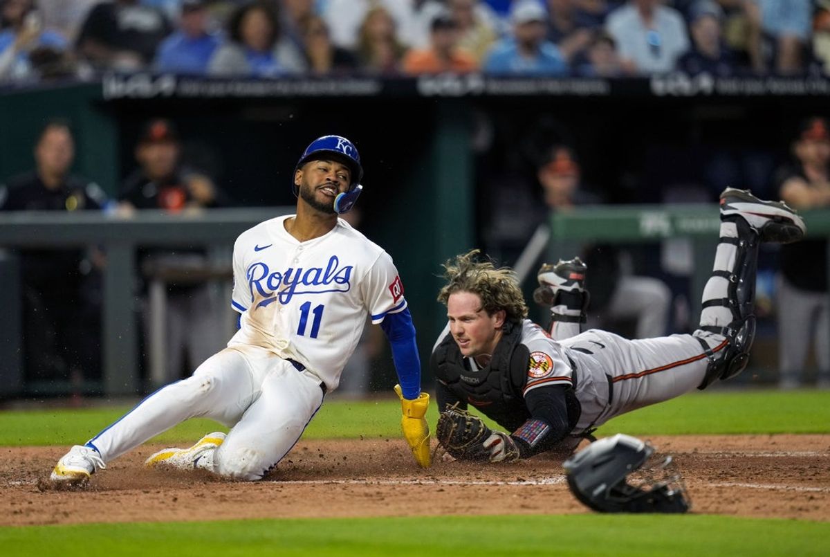 Apr 21, 2026; Kansas City, Missouri, USA; Kansas City Royals third baseman Maikel Garcia (11) slides into home to score a run against Baltimore Orioles catcher Adley Rutschman (35) during the fifth inning at Kauffman Stadium. Mandatory Credit: Jay Biggerstaff-Imagn Images