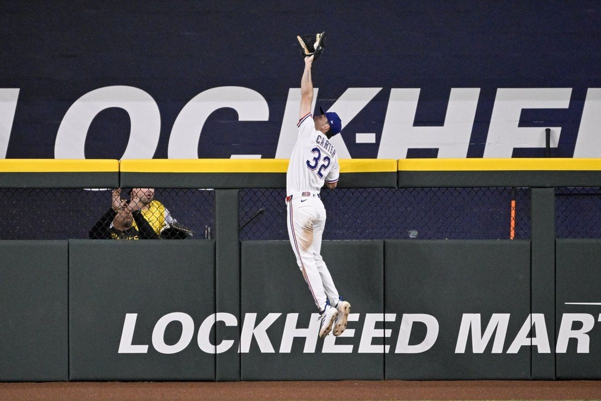 Apr 21, 2026; Arlington, Texas, USA; Texas Rangers center fielder Evan Carter (32) catches a fly ball hit by Pittsburgh Pirates center fielder Oneil Cruz (not pictured) to end the fifth inning wth runners in scoring position at Globe Life Field. Mandatory Credit: Jerome Miron-Imagn Images
