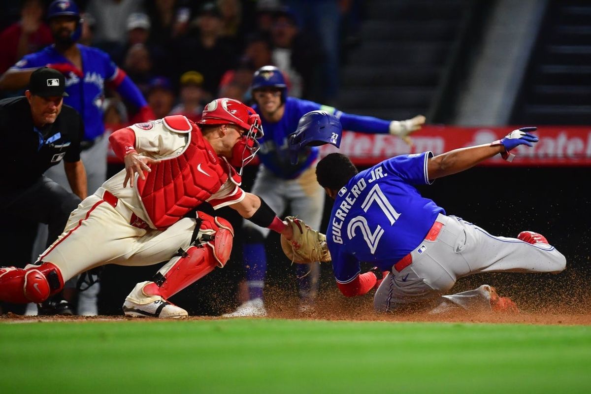 Apr 21, 2026; Anaheim, California, USA; Toronto Blue Jays first baseman Vladimir Guerrero Jr. (27) beats the tag of Los Angeles Angels catcher Logan O'Hoppe (14) to score during the eighth inning at Angel Stadium. Mandatory Credit: Gary A. Vasquez-Imagn Images