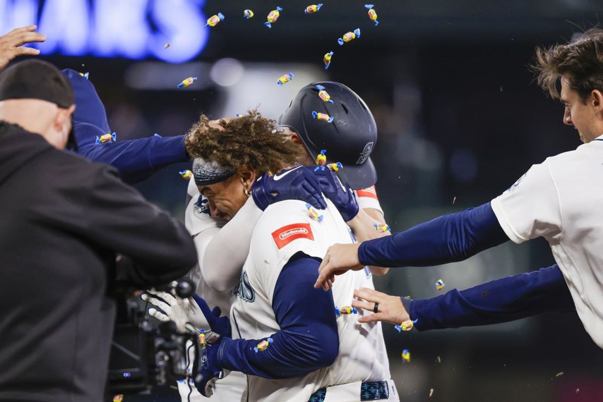 Apr 22, 2026; Seattle, Washington, USA; Seattle Mariners first baseman Josh Naylor (12) celebrates with teammates, including second baseman Cole Young (2, right) after hitting a walk-off RBI-single against the Athletics during the ninth inning at T-Mobile Park. Mandatory Credit: Joe Nicholson-Imagn Images