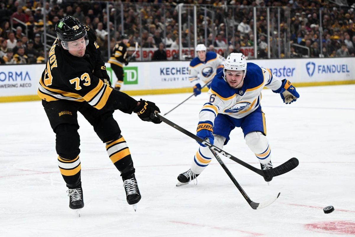 Apr 23, 2026; Boston, Massachusetts, USA; Boston Bruins defenseman Charlie McAvoy (73) clears the puck against Buffalo Sabres left wing Zach Benson (6) during the second period of game three of the first round of the 2026 Stanley Cup Playoffs at the TD Garden. Mandatory Credit: Brian Fluharty-Imagn Images