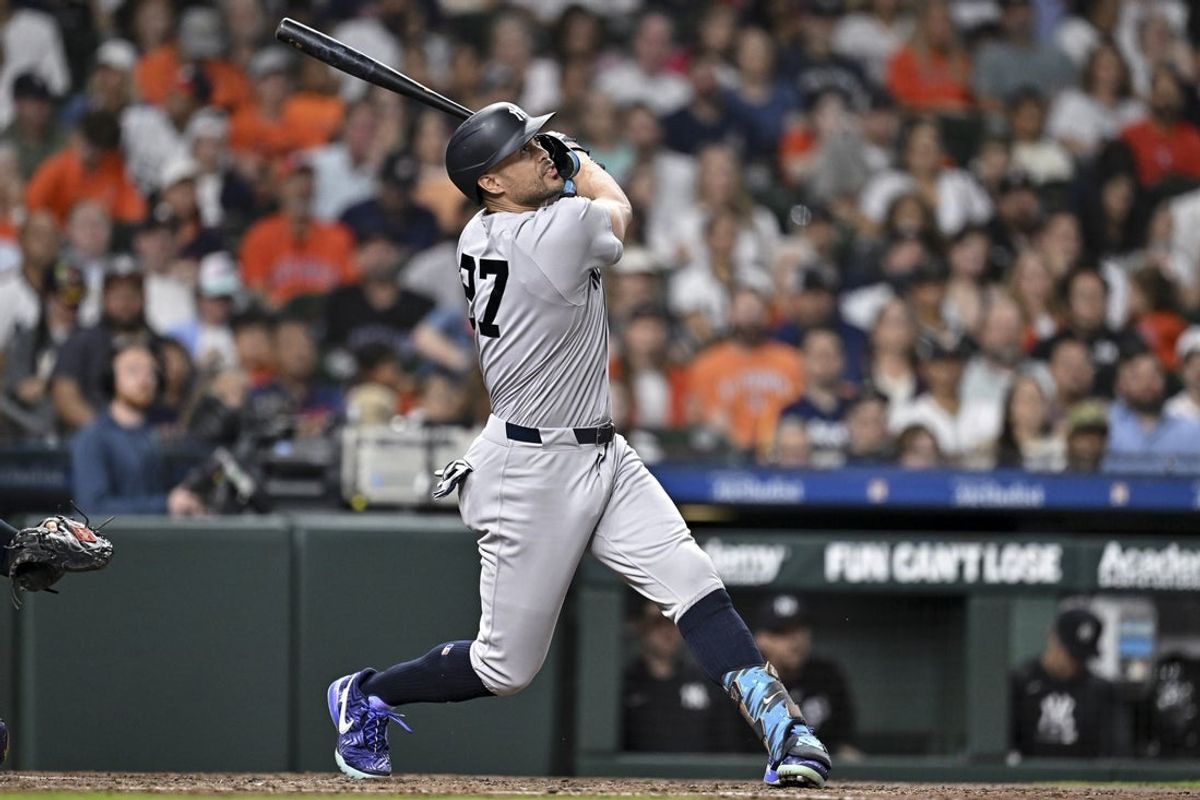 Apr 24, 2026; Houston, Texas, USA; New York Yankees designated hitter Giancarlo Stanton (27) hits the ball in the third inning against the Houston Astros at Daikin Park. Mandatory Credit: Maria Lysaker-Imagn Images